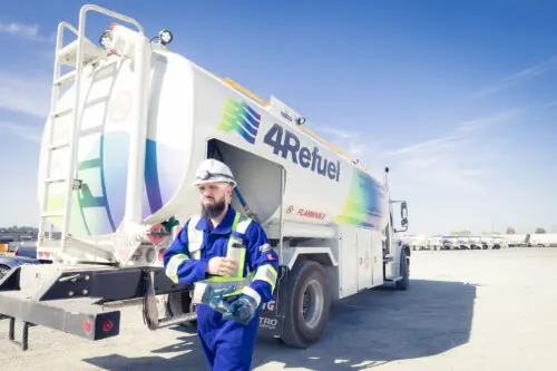 A 4Refuel driver in coveralls beside a fuel truck on site