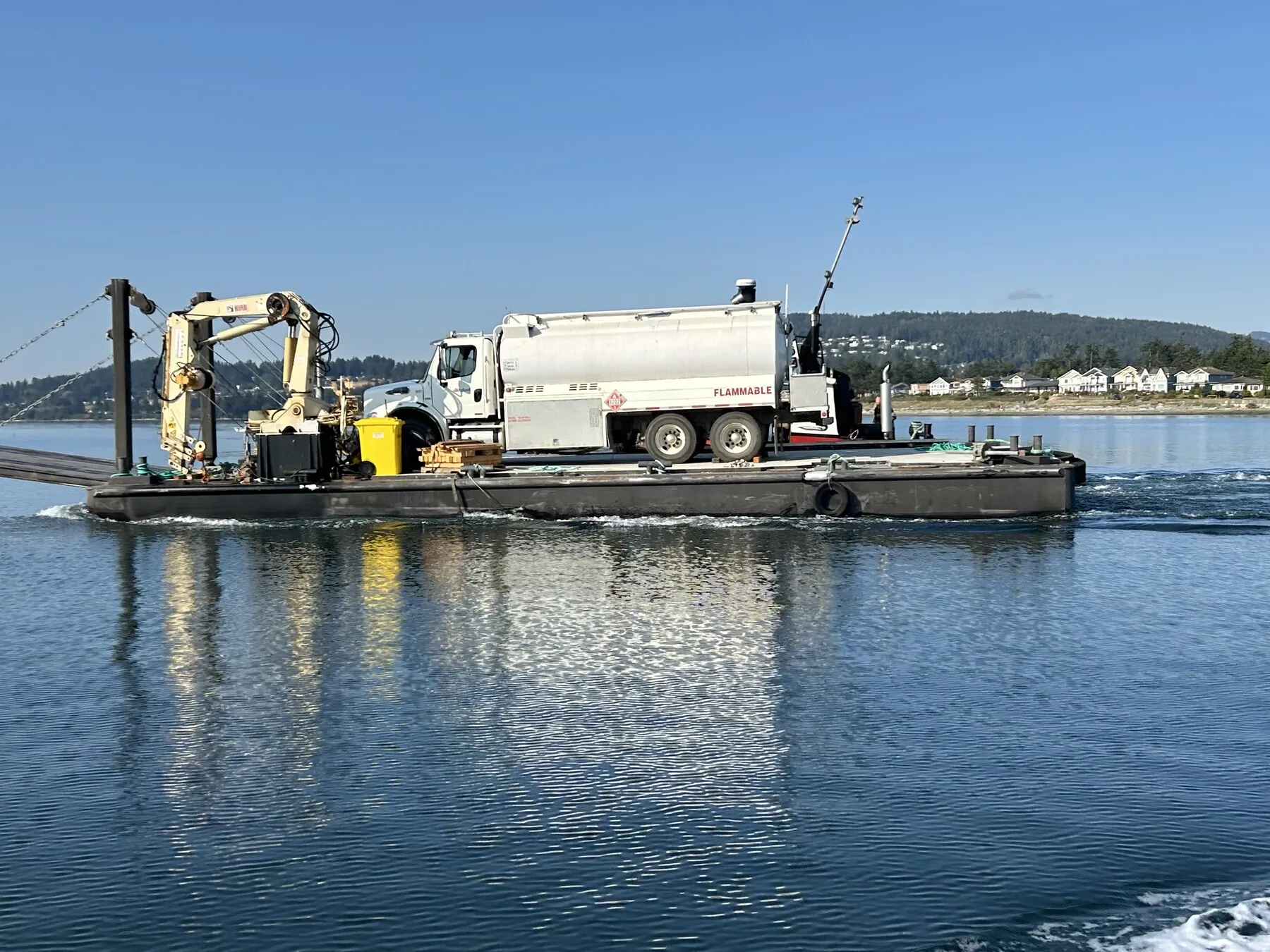 A 4Refuel fuel truck crossing the water on a barge to reach a remote site